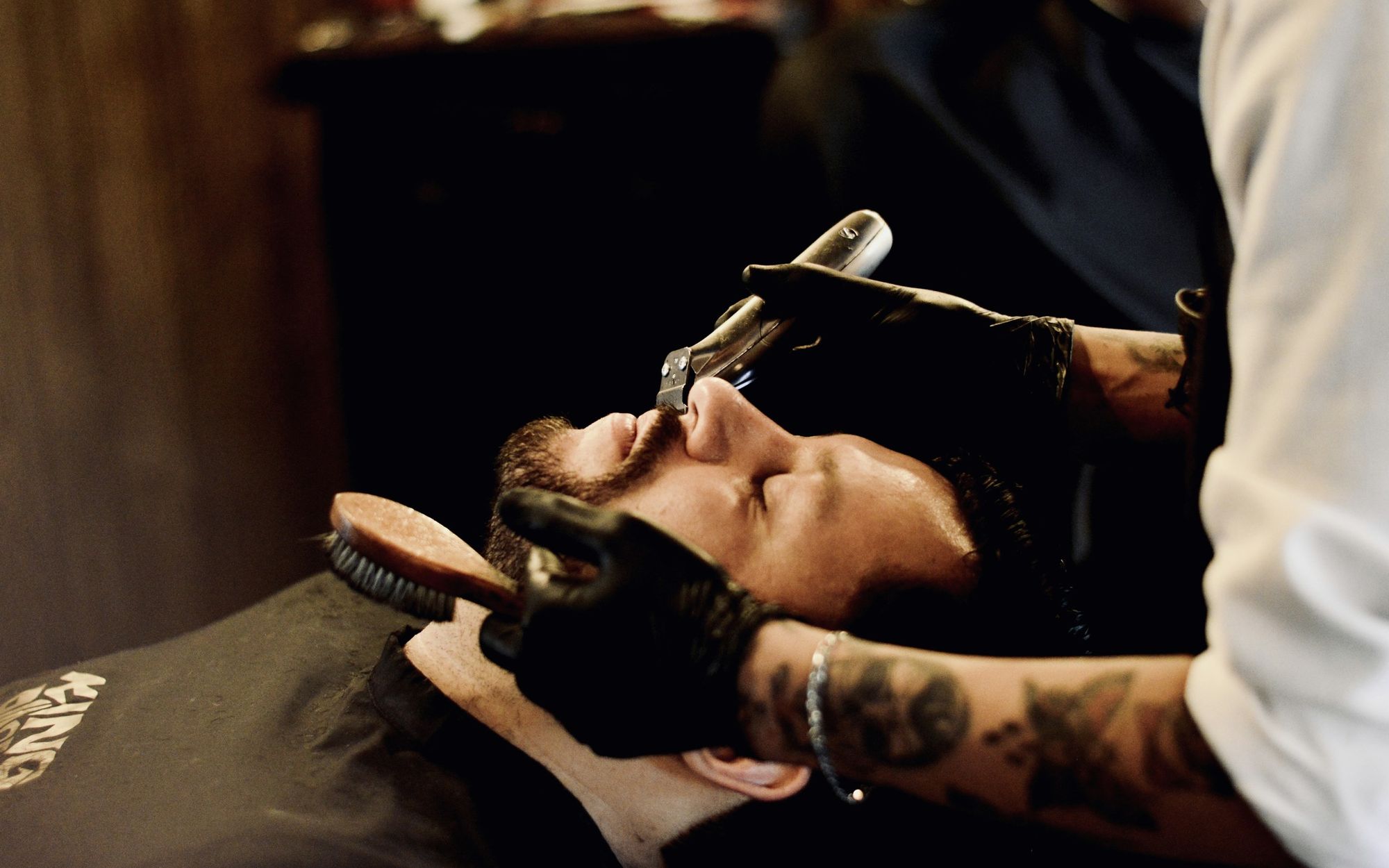 A barber shaving a client with a straight razor