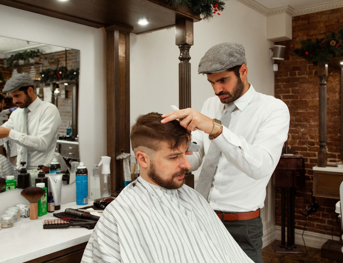 A barber studying a client’s hair before the cut
