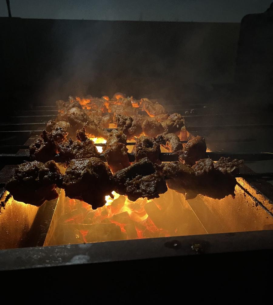 Meat over glowing charcoal late at night