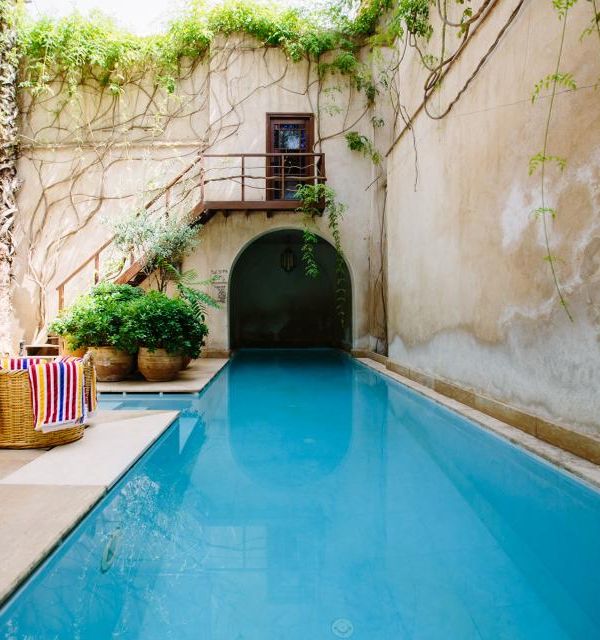A sunlit plunge pool in a stone courtyard