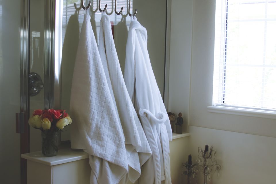 White robes hanging by a bright window