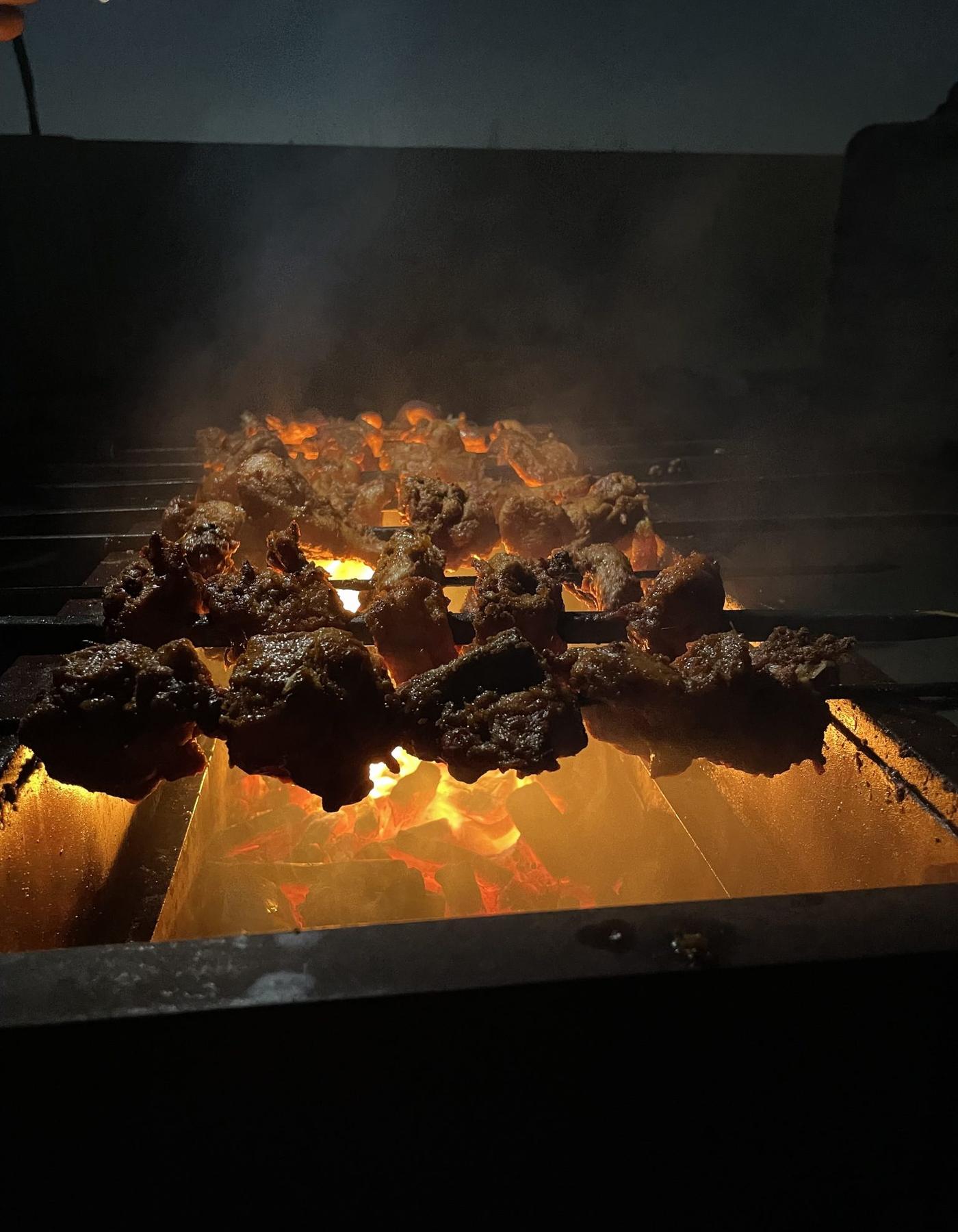 Meat cooking over glowing coals